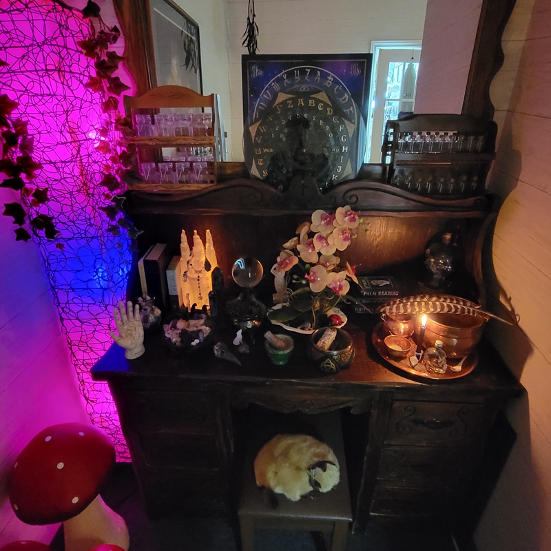 Crystal balls, pendulums, palmistry hand, and metaphysical tools arranged on a wooden altar in The Zen Shop’s Reading Parlour