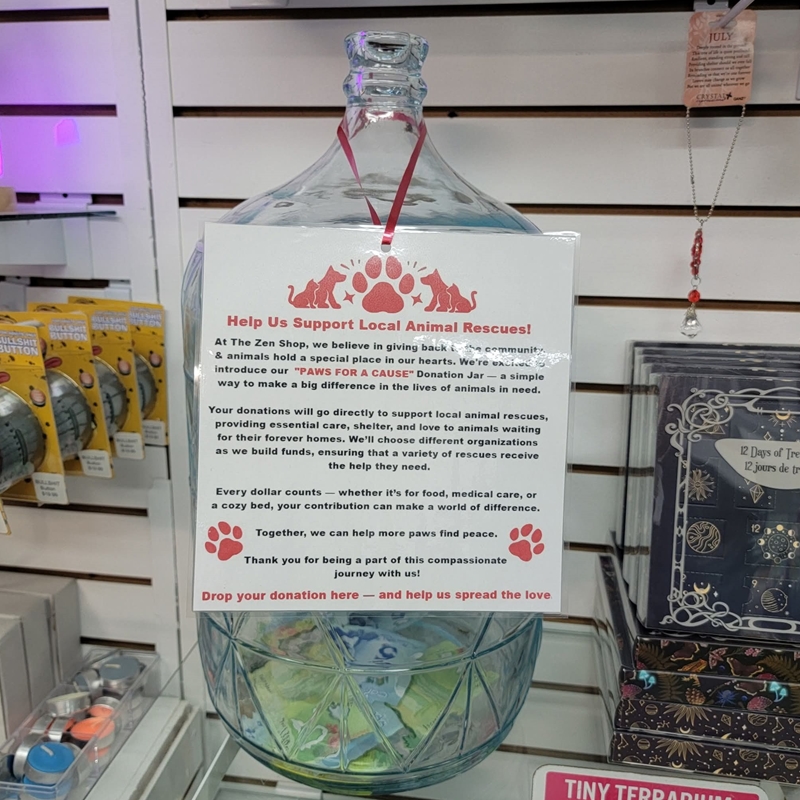 Zen Shop’s Paws for a Cause donation jar at checkout supporting local animal rescues with customer contributions.