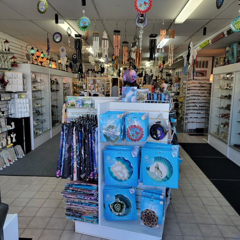 View of The Zen Shop’s front entrance showcasing colorful wind spinners, altar cloths, and metaphysical tapestries in a vibrant and welcoming spiritual retail space in Oshawa.